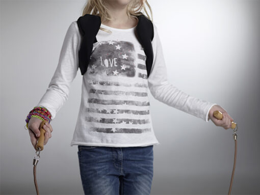 Young child wearing Medtronic pump harness with pump pocket on back